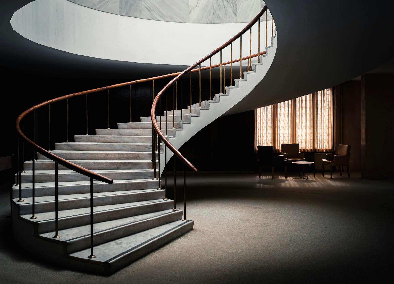 Sculptural spiral staircase in a quiet, softly lit interior
